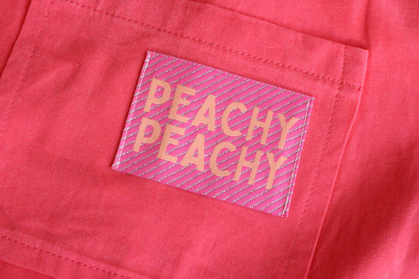 Large peach-colored woven sewing labels from The Cosy Club Handmade, featuring the Peachy Peach design for clothing and crafts.