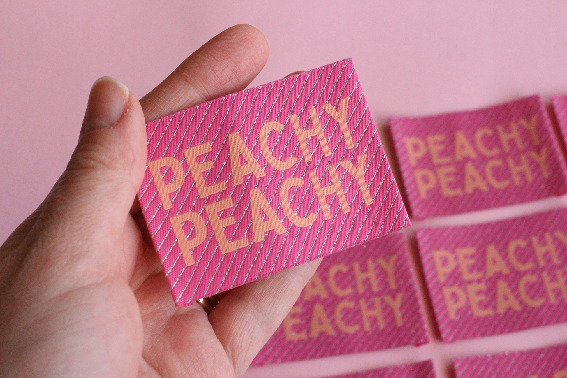 Large peach-colored woven sewing labels featuring "Peachy Peach" text from The Cosy Club Handmade, designed for fabric and craft projects.
