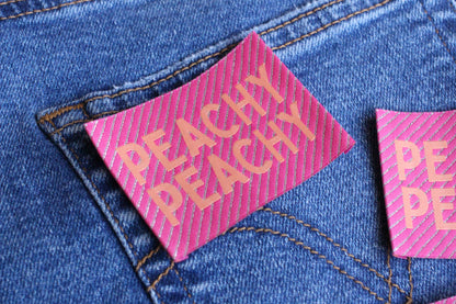 Large Peachy Peach sewing labels by The Cosy Club Handmade, woven fabric with decorative edges for clothing or craft projects.
