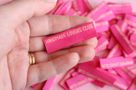 Handmade Lovers Club sewing labels with side seam design by The Cosy Club Handmade, shown on a fabric seam.