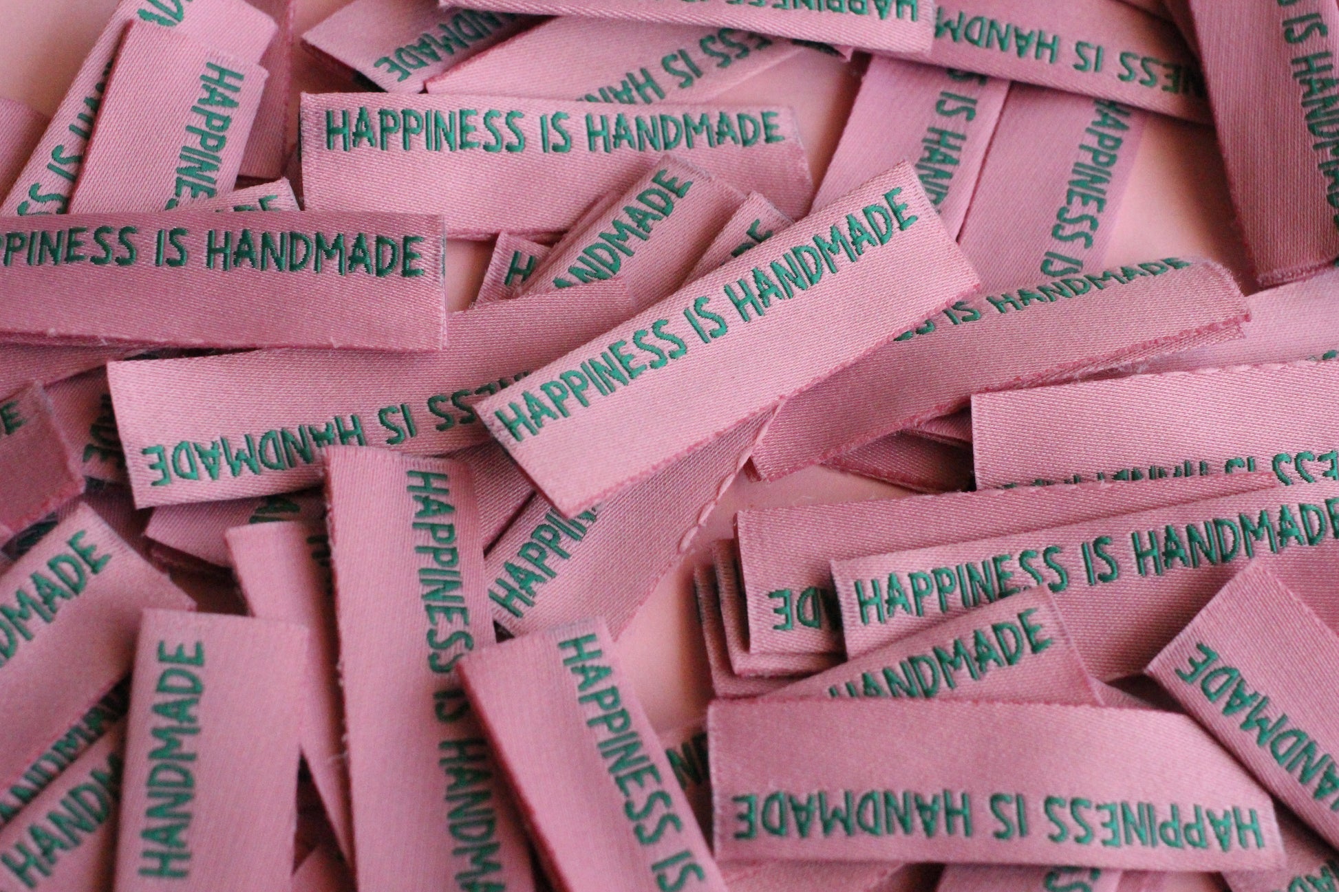 Six handmade side seam sewing labels from The Cosy Club Handmade, featuring elegant "Happiness is Handmade" embroidered design.