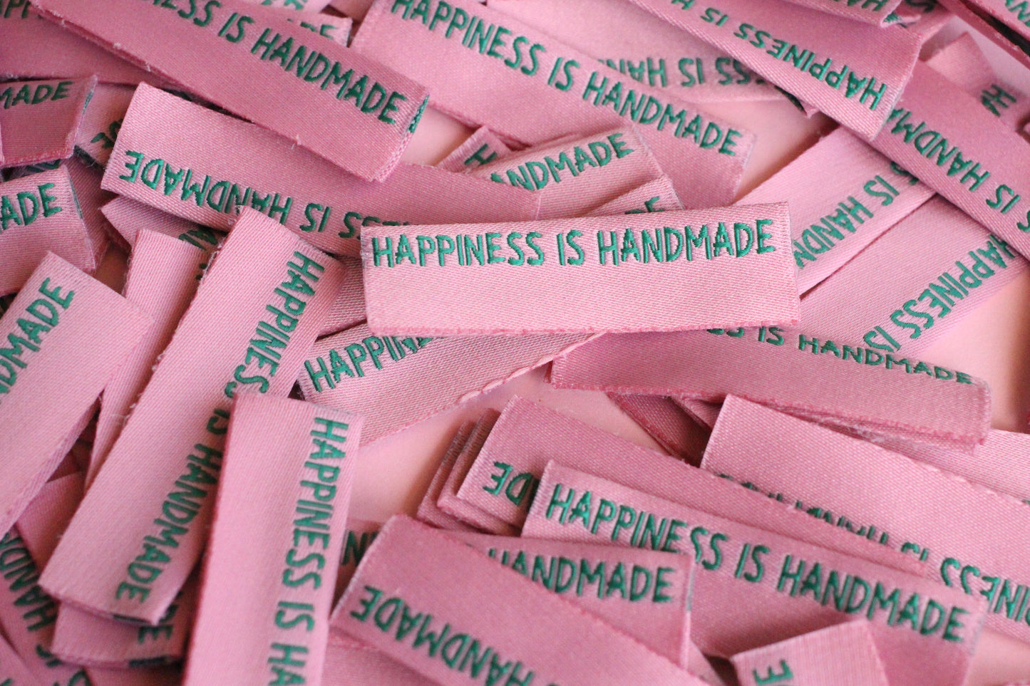 Six handmade side seam sewing labels by The Cosy Club Handmade with "Happiness is Handmade" text, designed for garment branding.