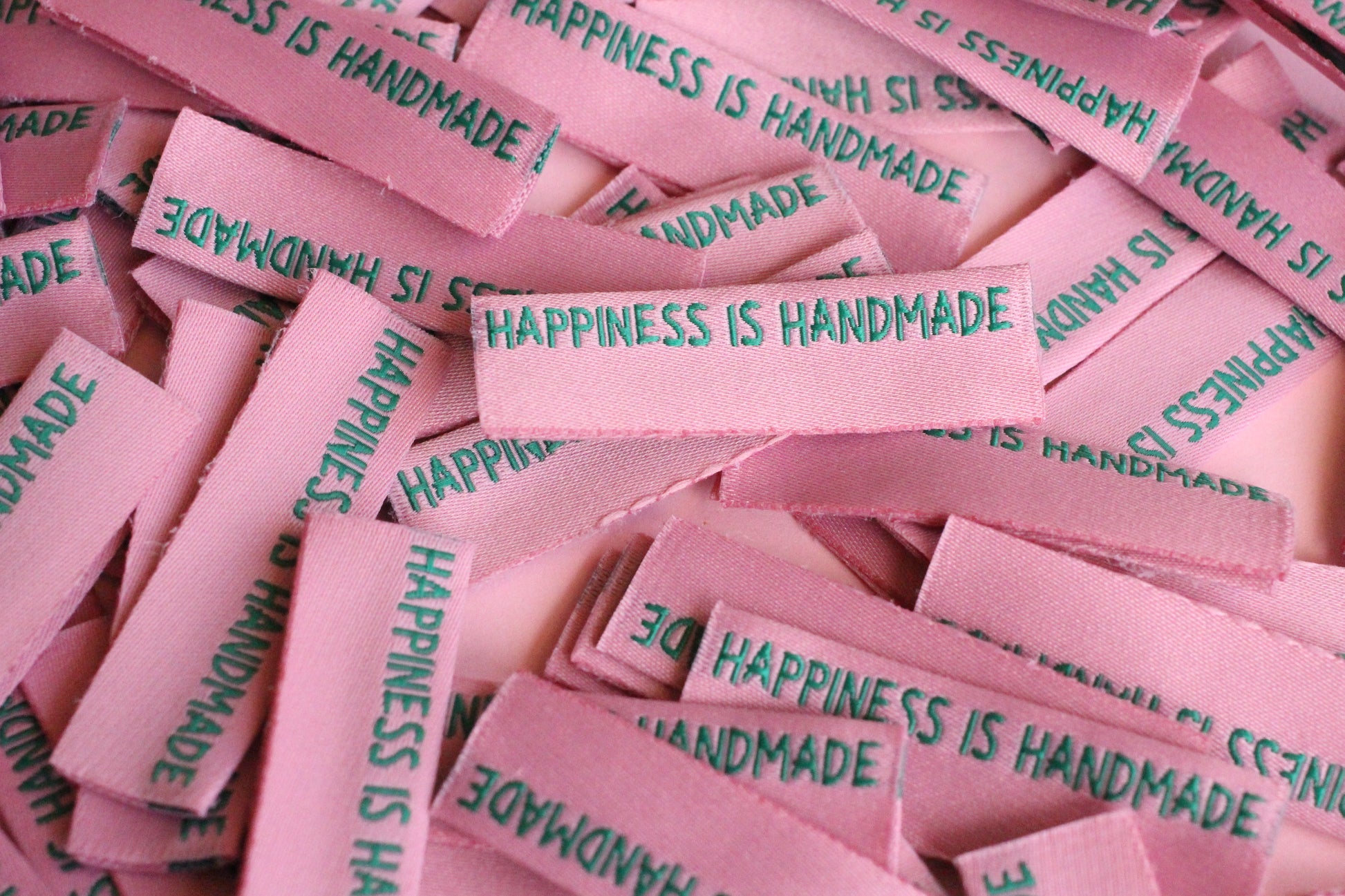 Six handmade side seam sewing labels by The Cosy Club Handmade with "Happiness is Handmade" text, designed for garment branding.