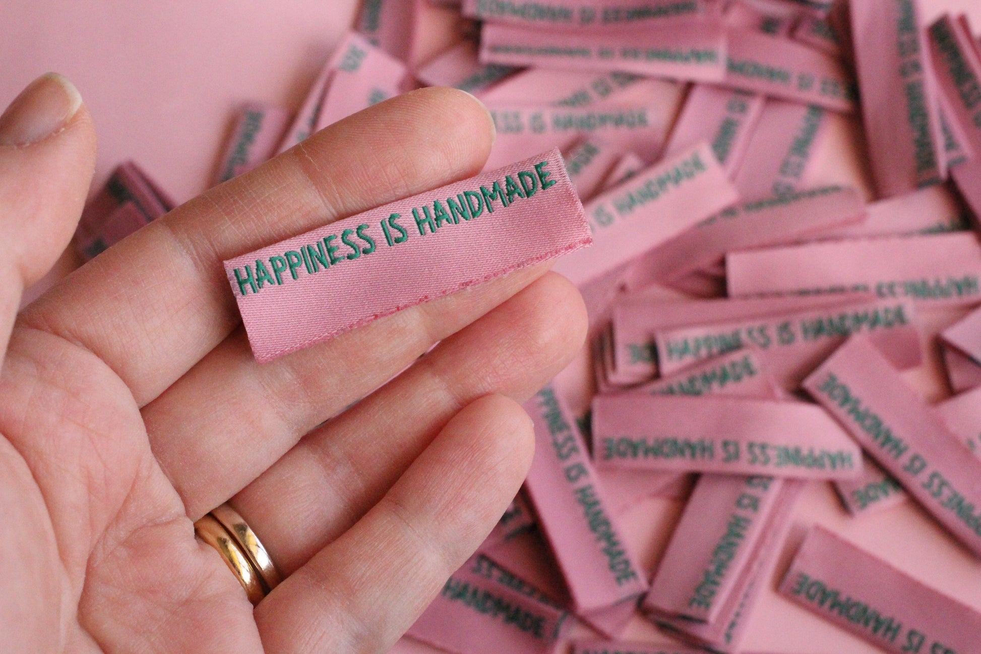 Six side seam handmade sewing labels from The Cosy Club Handmade with "Happiness is Handmade" text for personalized clothing.