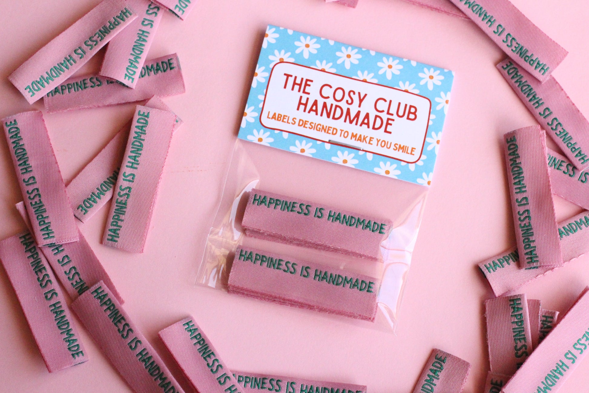 Six handmade side seam sewing labels from The Cosy Club Handmade with positive "Happiness is Handmade" text for clothing tags.