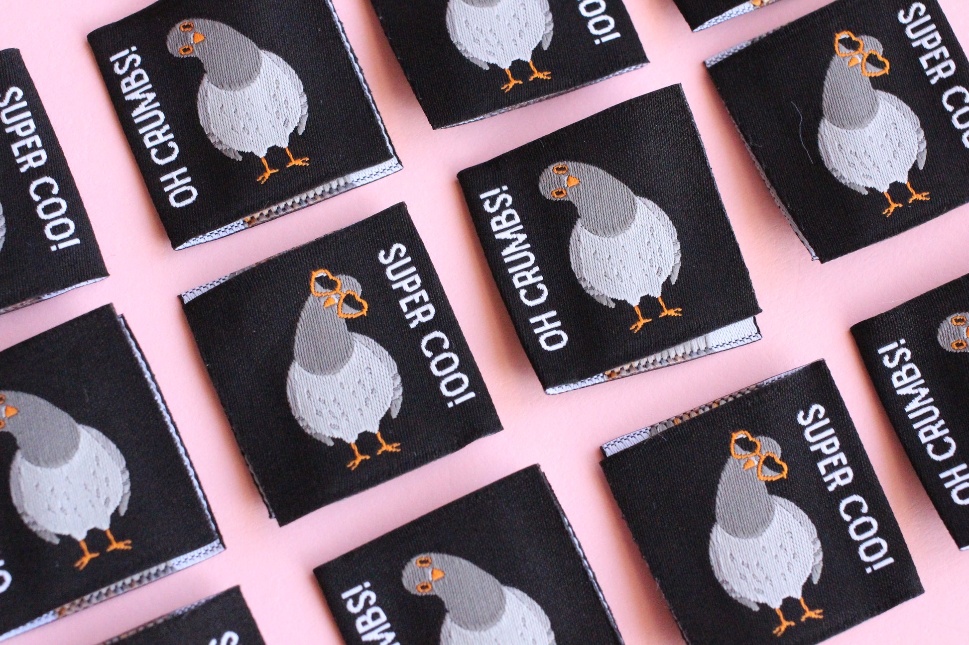 Six double-sided Pigeon sewing labels from The Cosy Club Handmade, featuring colorful bird designs on white fabric.