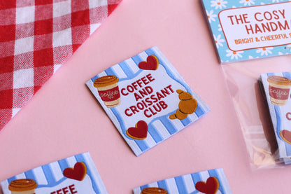 Set of five sewing labels featuring coffee and croissant designs from The Cosy Club Handmade for clothing and accessories.