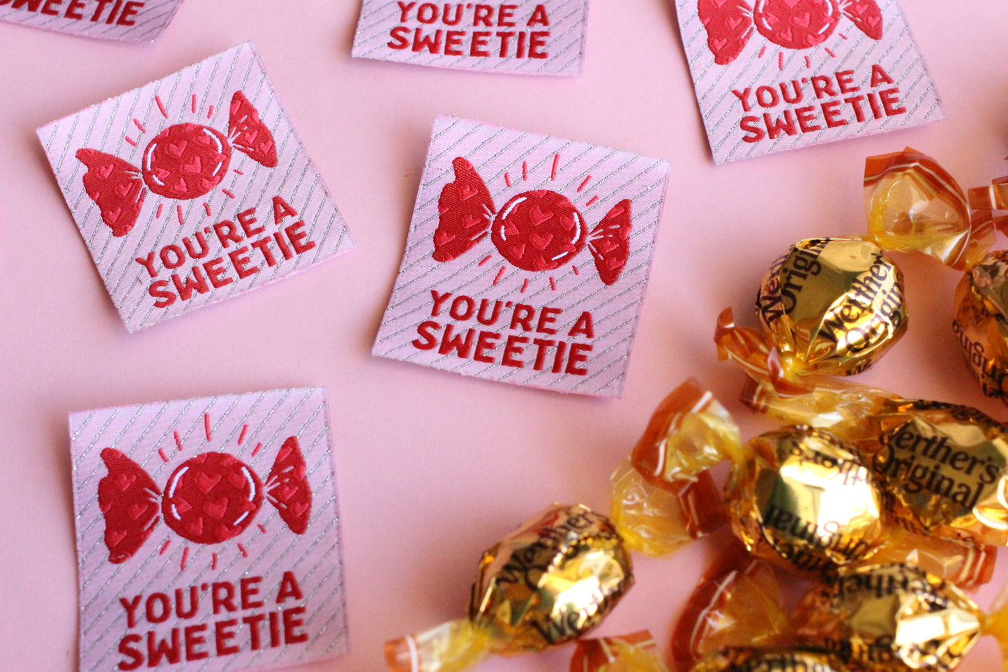 Five colorful "You're a SWEETIE" candy-themed sewing labels by The Cosy Club Handmade, featuring playful designs on fabric labels.