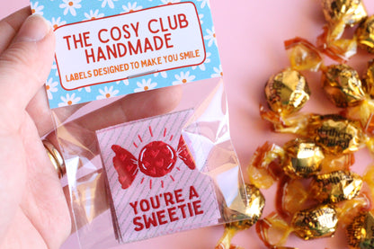You’re a SWEETIE candy sewing labels by The Cosy Club Handmade, featuring colorful, playful fabric labels for crafts and sewing projects.