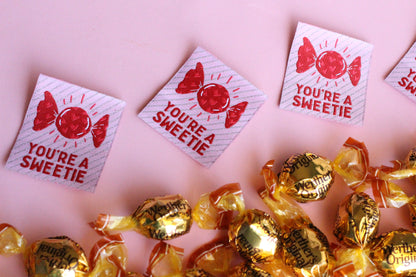 Handmade "You're a SWEETIE" candy-themed sewing labels by The Cosy Club Handmade, featuring colorful labels on fabric.