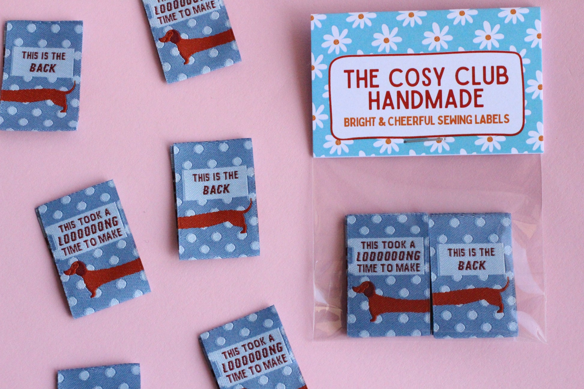Blue sausage dog sewing labels from The Cosy Club Handmade, double-sided fabric tags featuring adorable dog design for crafting and sewing projects.