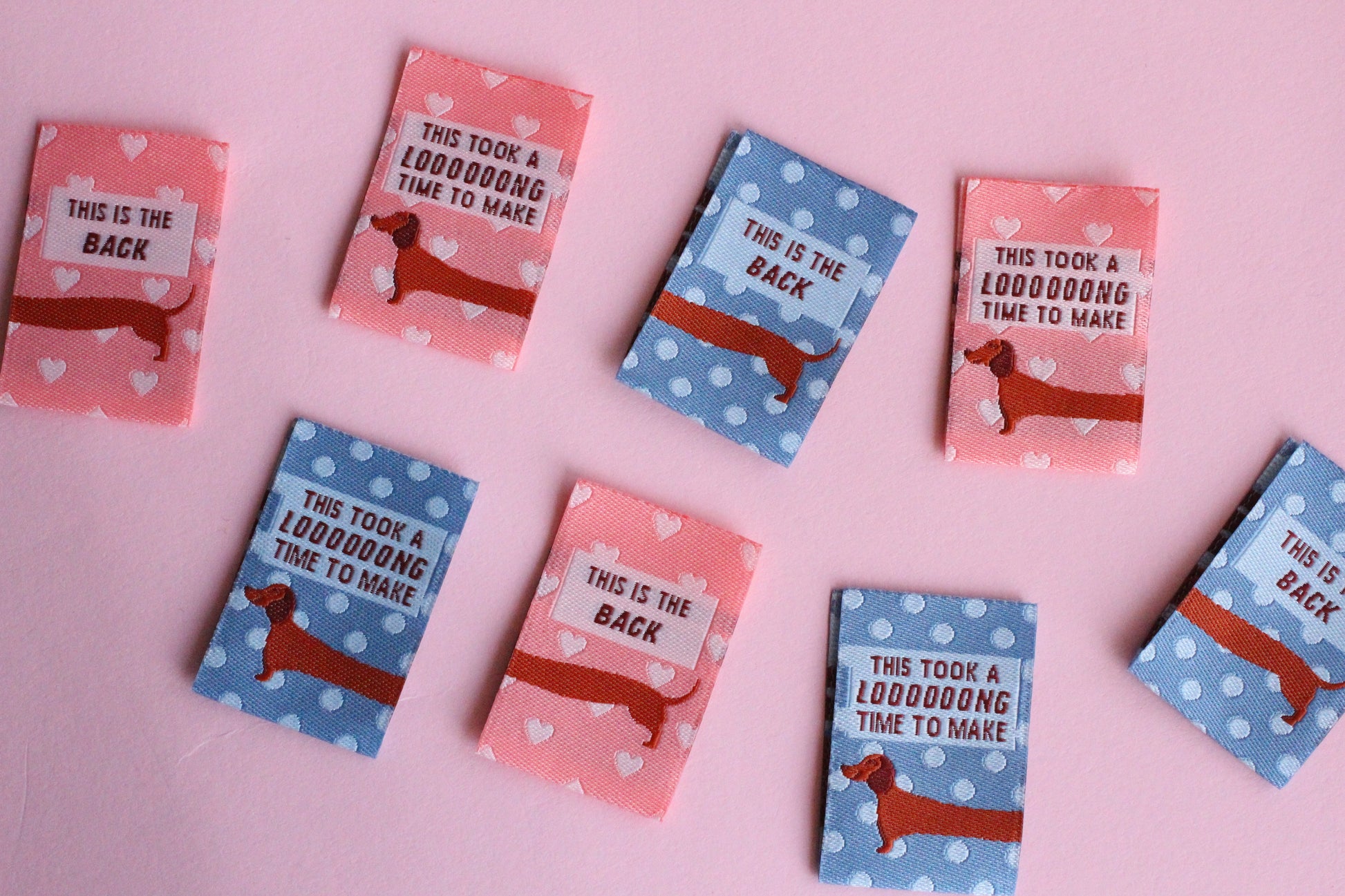 Pink and blue sausage dog sewing labels from The Cosy Club Handmade, double-sided fabric labels for sewing projects.