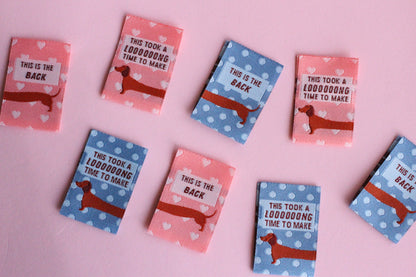 Pink and blue sausage dog sewing labels from The Cosy Club Handmade, double-sided fabric labels for sewing projects.
