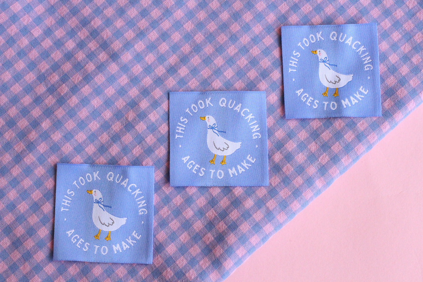 White goose sewing labels from The Cosy Club Handmade, showcasing five neatly stitched labels with "Took Quacking Ages To Make" text.