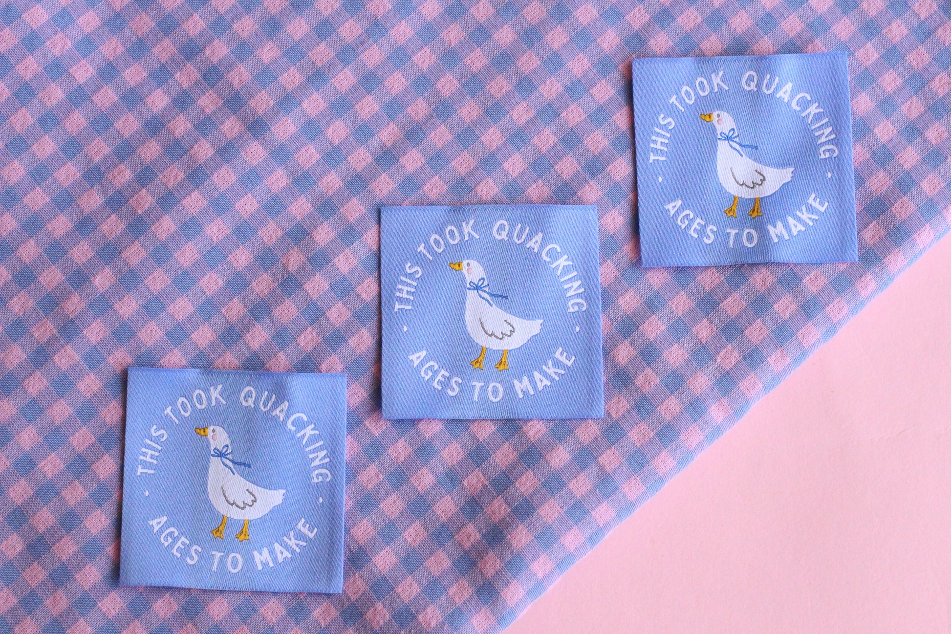 White goose sewing labels from The Cosy Club Handmade, showcasing five neatly stitched labels with "Took Quacking Ages To Make" text.