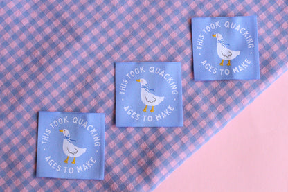 White goose sewing labels from The Cosy Club Handmade, showcasing five neatly stitched labels with "Took Quacking Ages To Make" text.