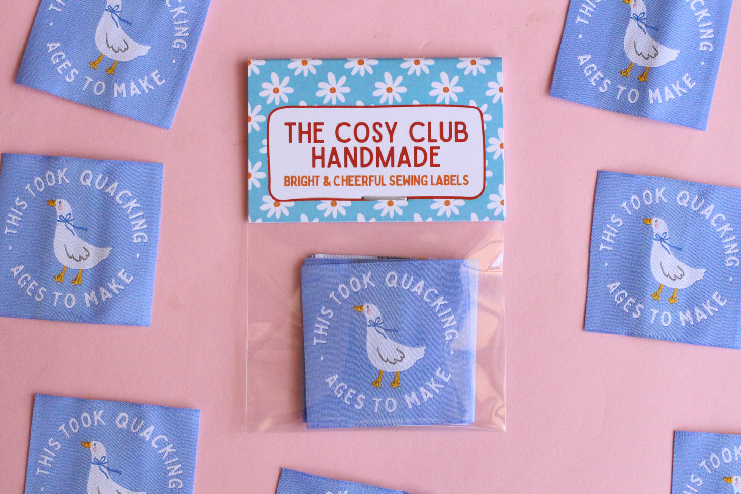 White goose sewing labels with "This Took Quacking Ages To Make" text, by The Cosy Club Handmade, featuring five labels on a white background.