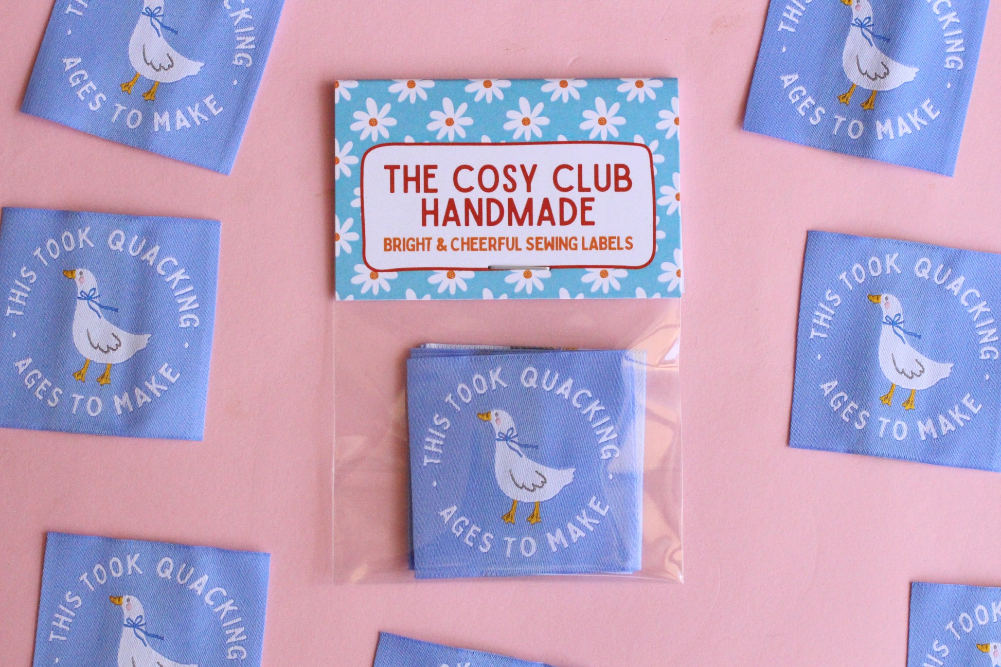 White goose sewing labels with "This Took Quacking Ages To Make" text, by The Cosy Club Handmade, featuring five labels on a white background.