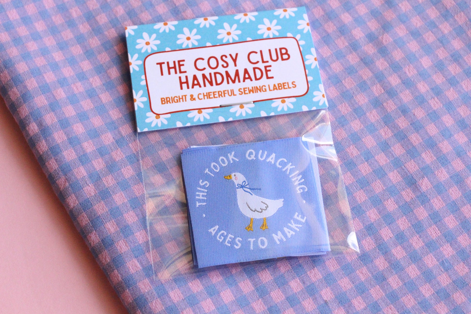 White goose sewing labels with "This Took Quacking Ages To Make" text, crafted by The Cosy Club Handmade, featuring detailed stitching.