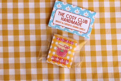 Handmade sewing labels with "Jam Packed With Love" by The Cosy Club Handmade, featuring colorful, fabric labels for homemade jams.